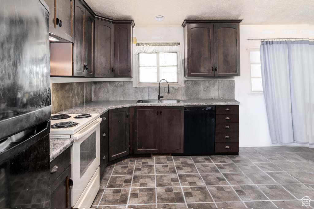 Kitchen with a sink, black appliances, dark brown cabinets, and decorative backsplash