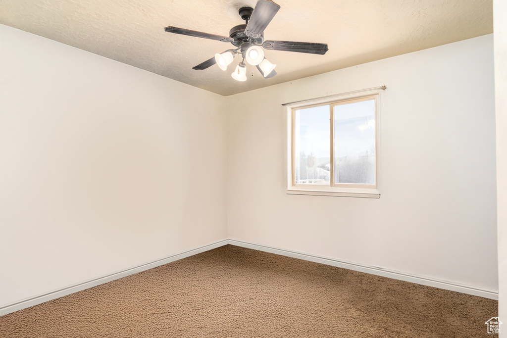 Spare room with carpet flooring, a ceiling fan, and baseboards