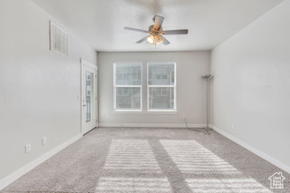 Carpeted empty room with ceiling fan and baseboards