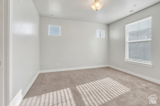 Carpeted empty room with baseboards