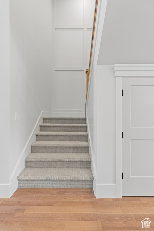 Stairway featuring wood finished floors and baseboards
