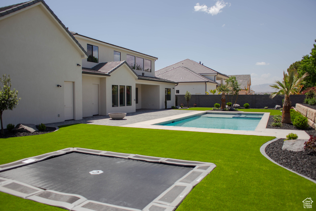 Rear view of property with a tile roof, stucco siding, and a patio area