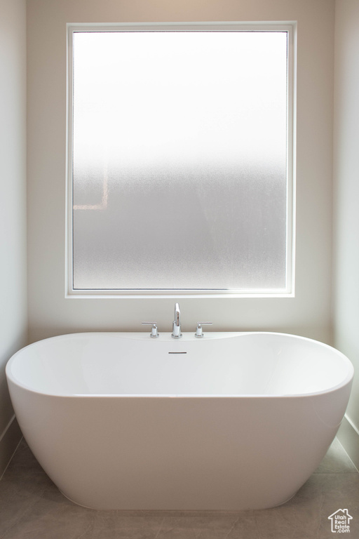 Full bath with a freestanding tub and tile patterned floors