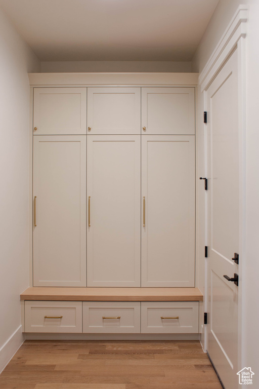 Mudroom featuring light wood-type flooring and baseboards