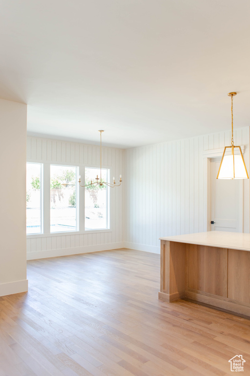 Kitchen with a chandelier, light wood-type flooring, and pendant lighting