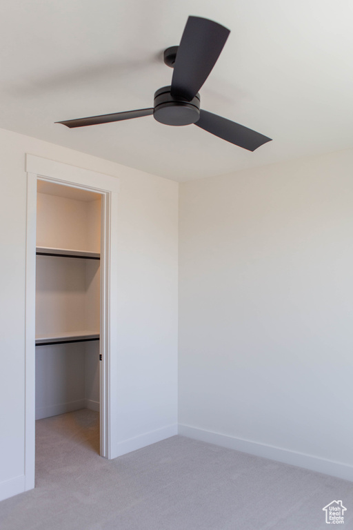 Unfurnished bedroom with carpet flooring, a walk in closet, baseboards, a ceiling fan, and a closet