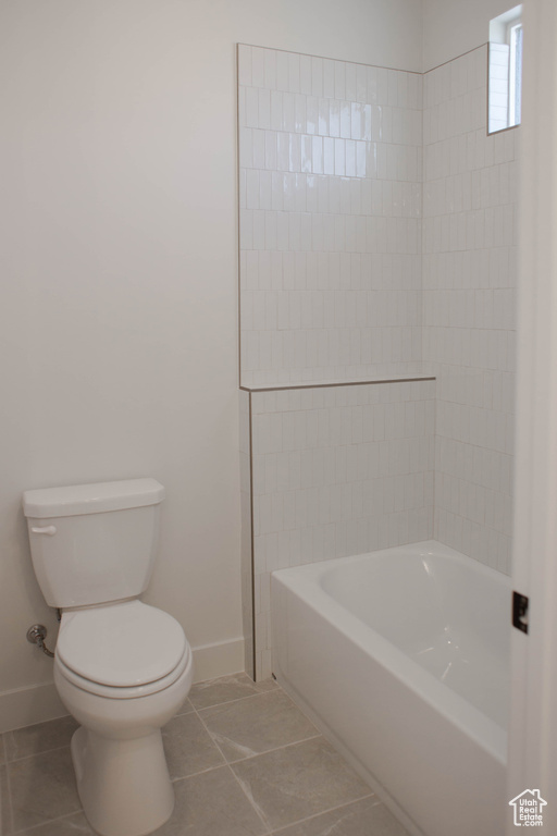 Full bath with baseboards, toilet, and tile patterned flooring
