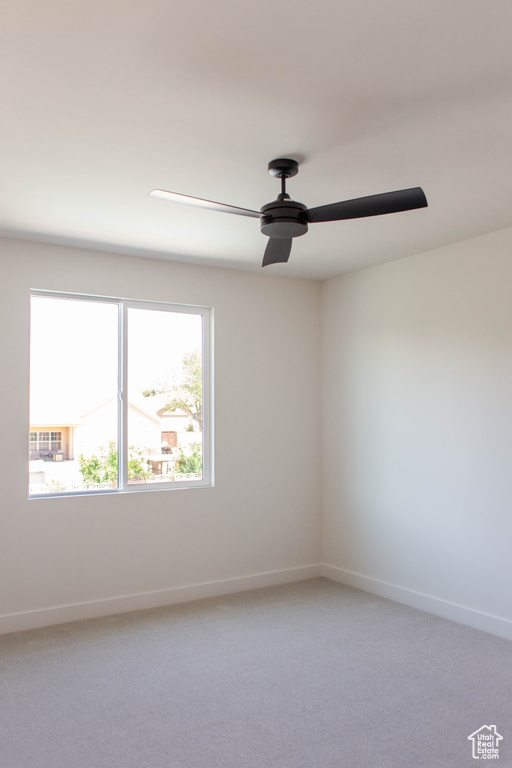 Unfurnished room featuring ceiling fan, baseboards, and light colored carpet