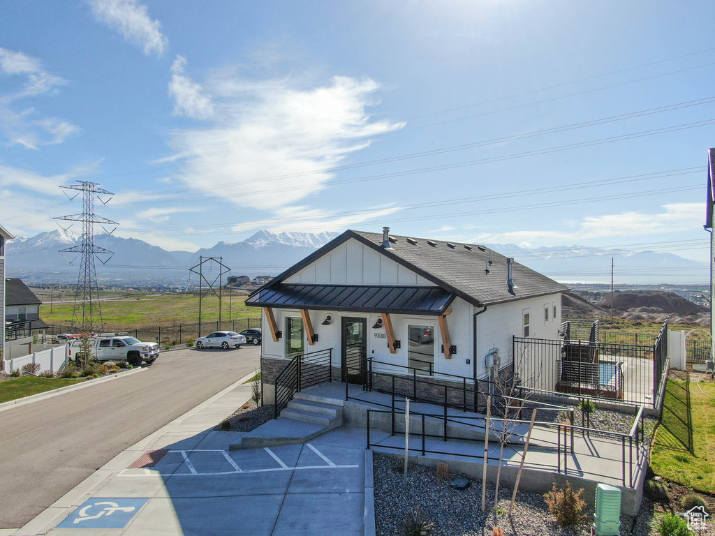 View of front of home with a mountain view, fence, a porch, and board and batten siding