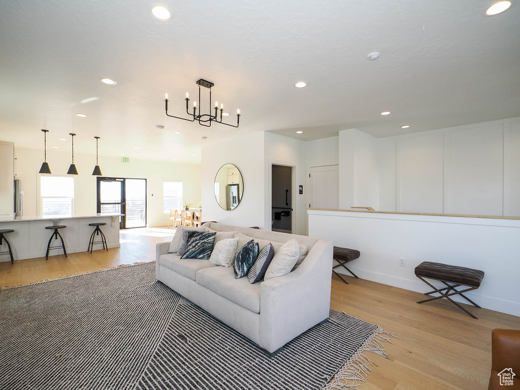 Living room with light wood-style floors, a chandelier, recessed lighting, and baseboards