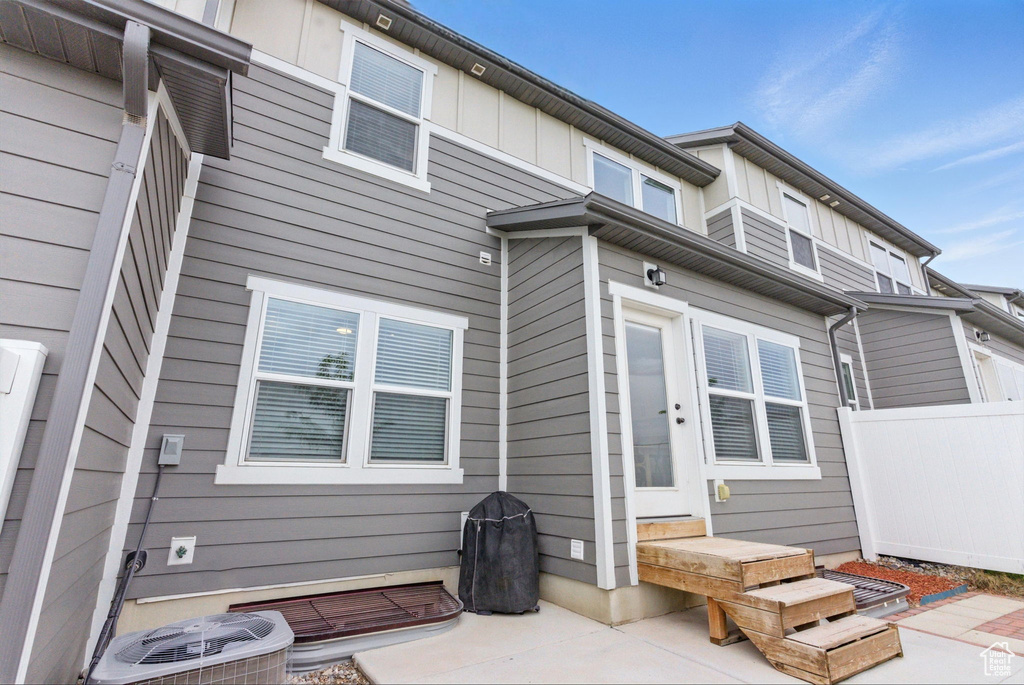 Back of house with fence, central AC, a patio area, and board and batten siding