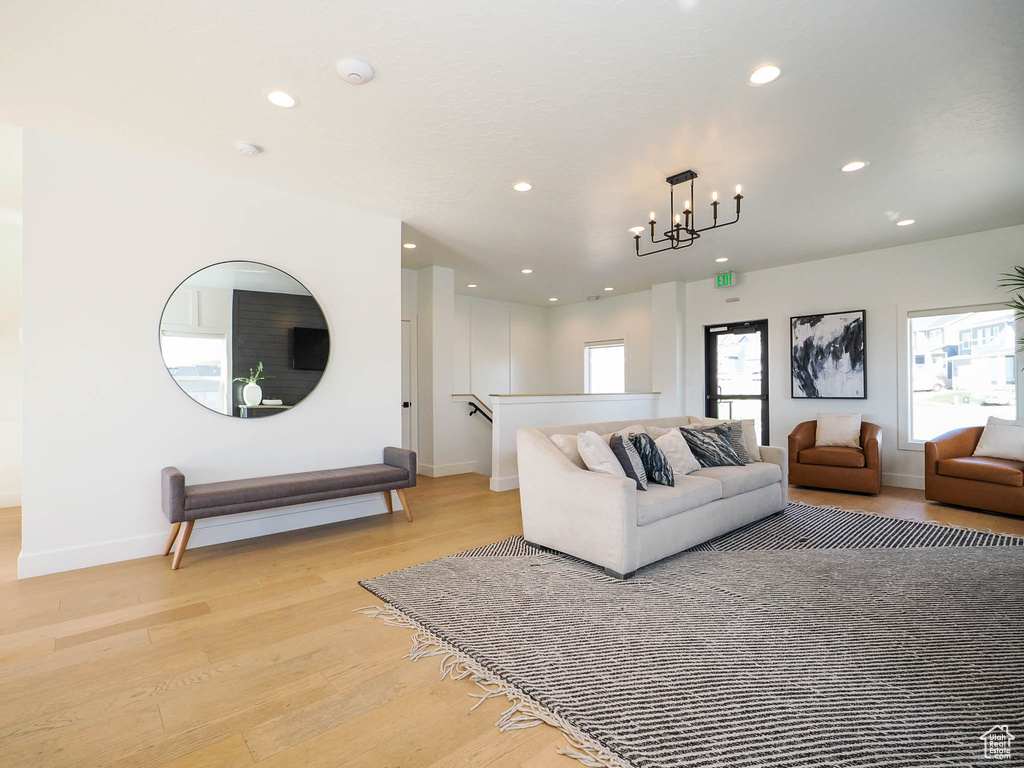 Living room with recessed lighting, baseboards, light wood-style floors, and a chandelier