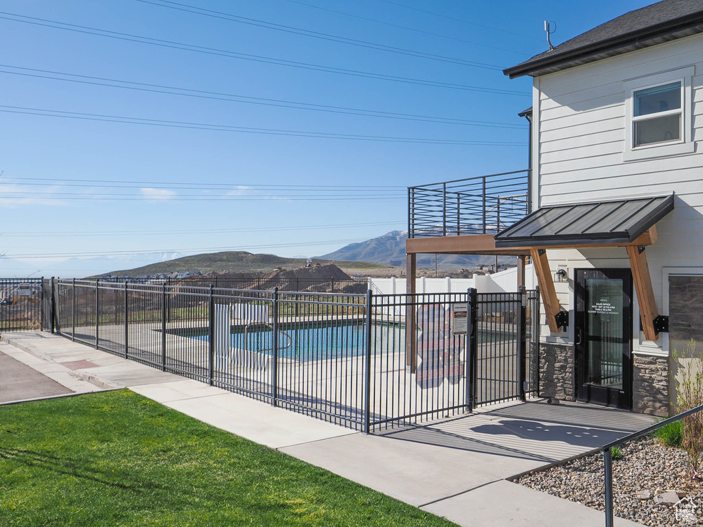 View of pool with a mountain view, fence, and a patio