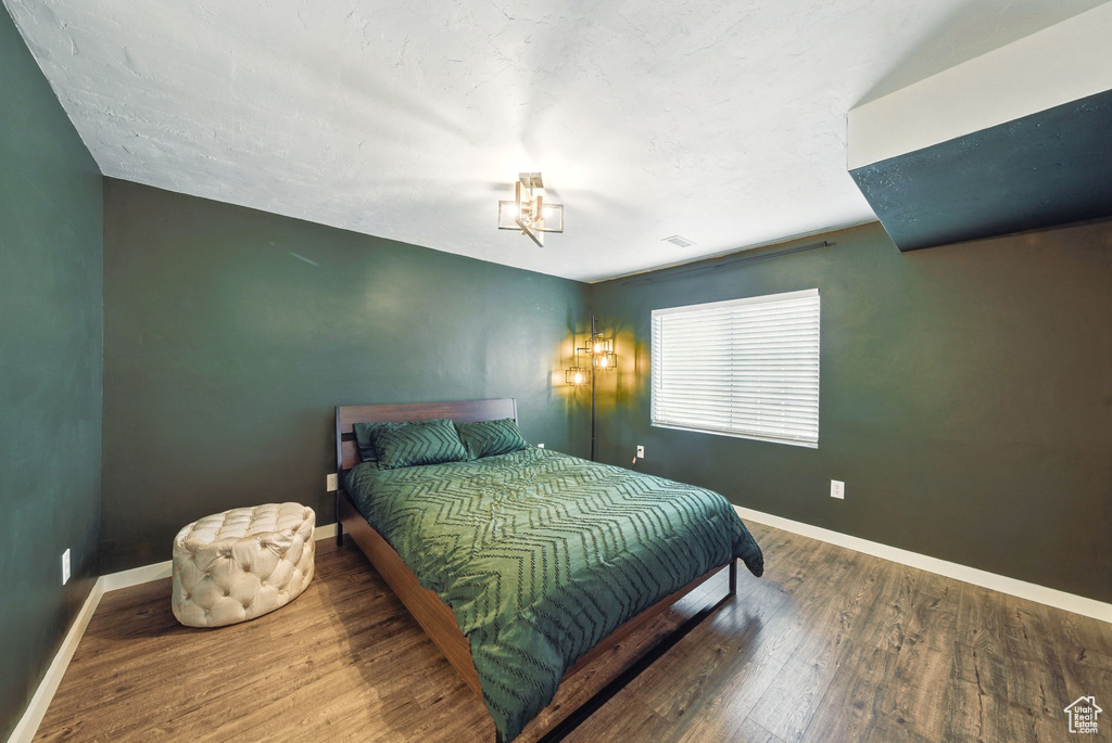 Bedroom with wood finished floors and baseboards