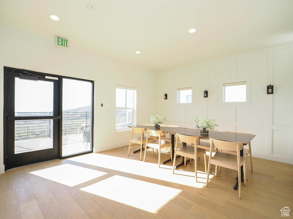 Dining area featuring a decorative wall, light wood finished floors, and recessed lighting