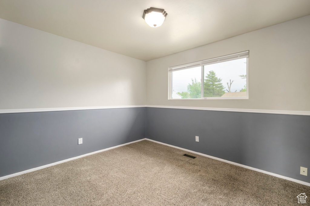 Spare room featuring carpet floors and baseboards