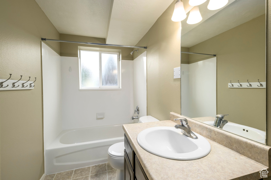 Bathroom featuring toilet, vanity, and shower / washtub combination