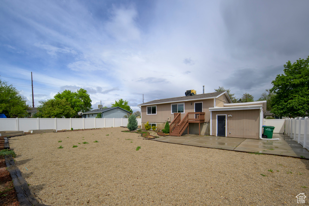 Rear view of house featuring a patio and a fenced backyard
