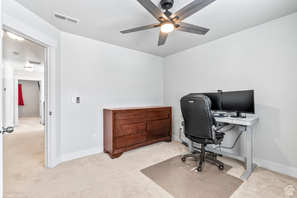 Carpeted office with ceiling fan and baseboards