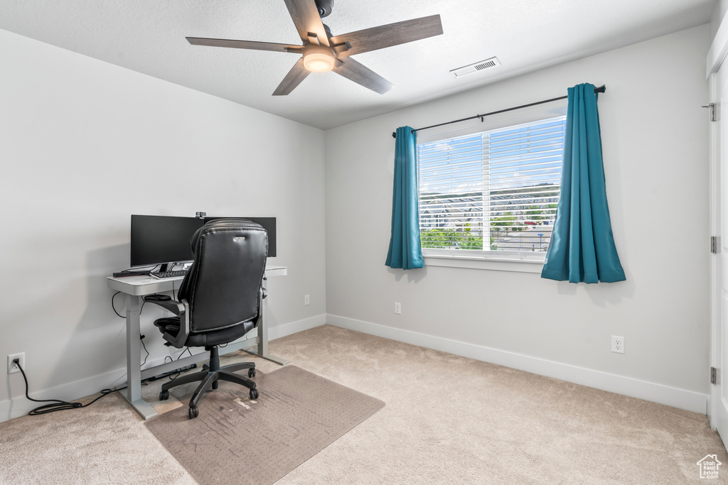 Office area with carpet flooring, baseboards, and ceiling fan
