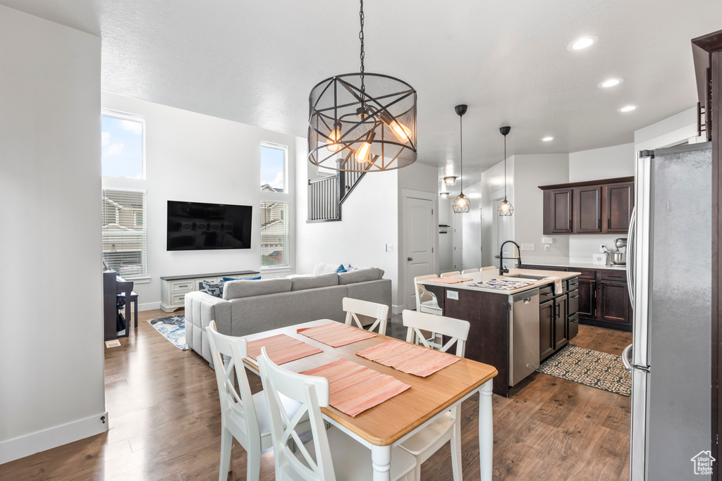 Dining room featuring a chandelier, recessed lighting, dark wood-style flooring, and baseboards