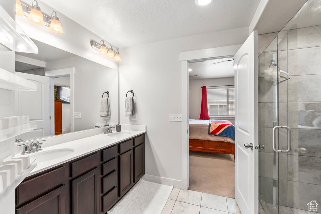 Ensuite bathroom featuring a stall shower, double vanity, baseboards, recessed lighting, and tile patterned floors