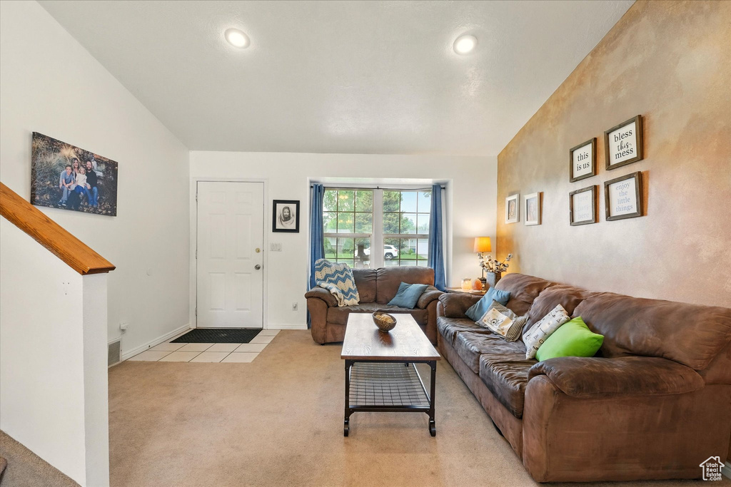 Living area with light carpet, light tile patterned floors, baseboards, and recessed lighting