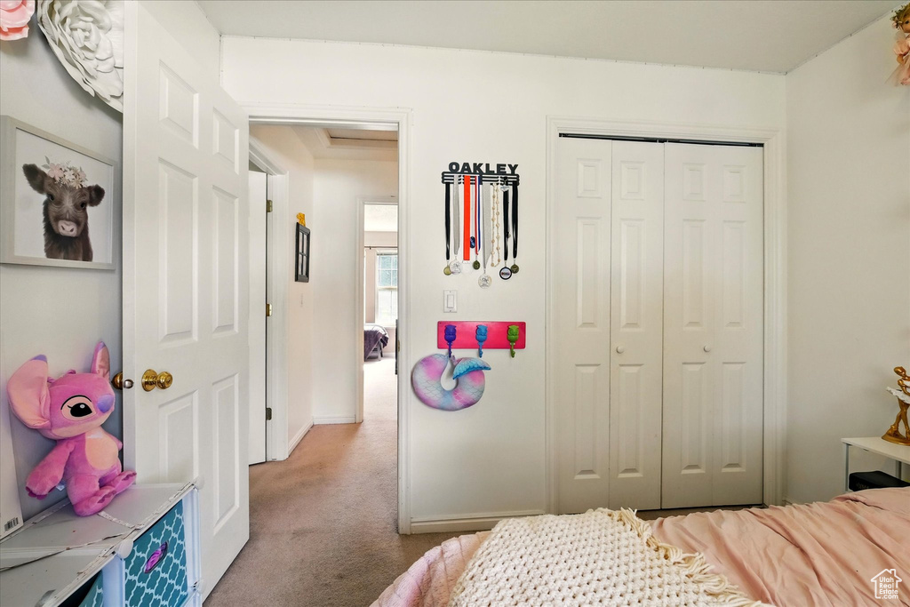 Carpeted bedroom with a closet and baseboards