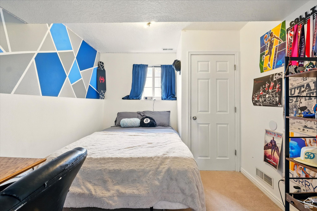 Bedroom with carpet flooring and a textured ceiling
