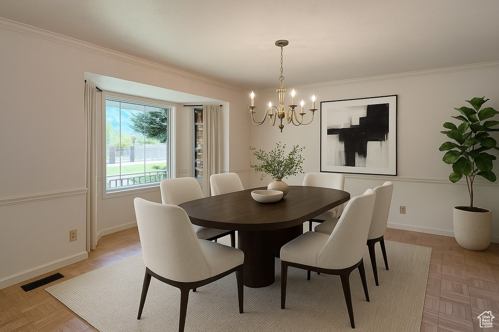 Dining room featuring a chandelier, ornamental molding, and baseboards