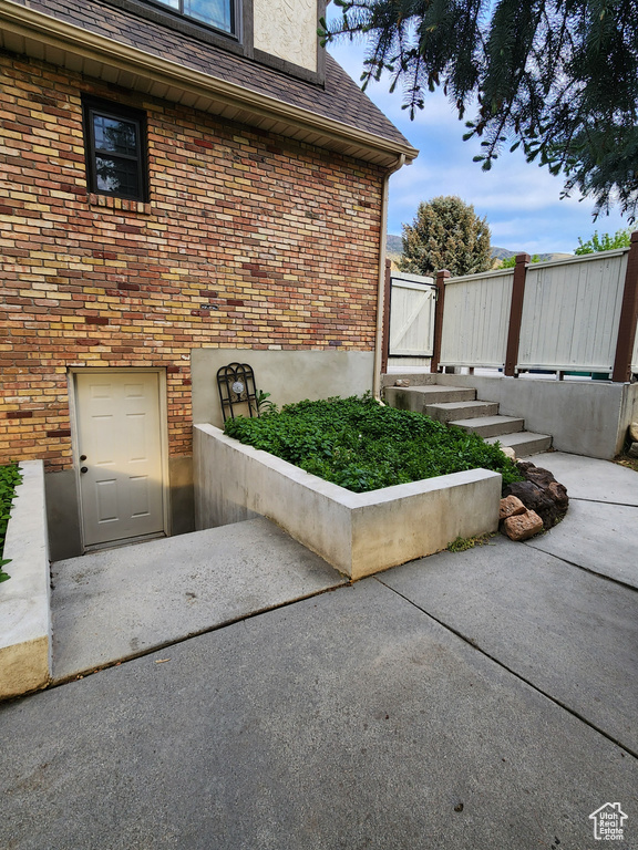 View of exterior entry with brick siding and a gate