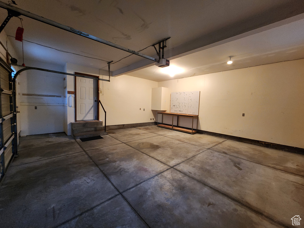 Garage with a garage door opener and baseboards