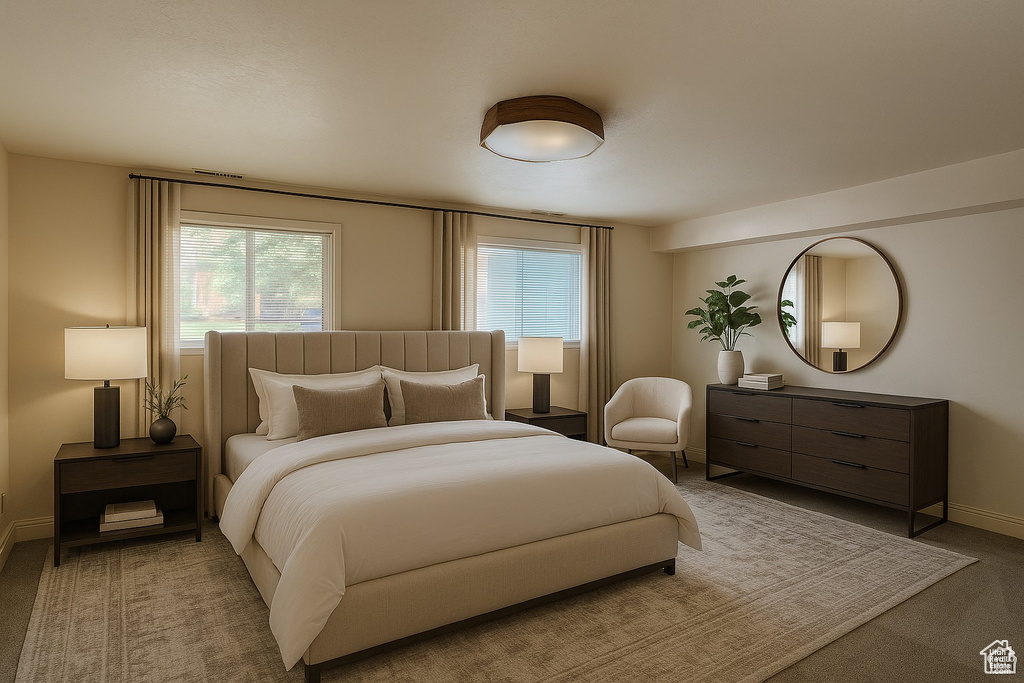 Carpeted bedroom with multiple windows and baseboards