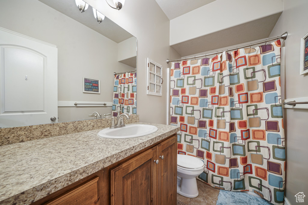 Bathroom featuring toilet, vanity, and a shower with shower curtain