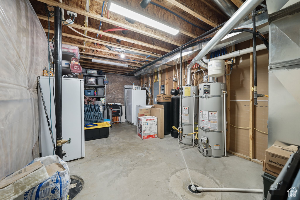 Unfinished basement featuring secured water heater and a water softener system