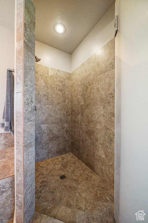 Bathroom featuring a tile shower and a textured ceiling