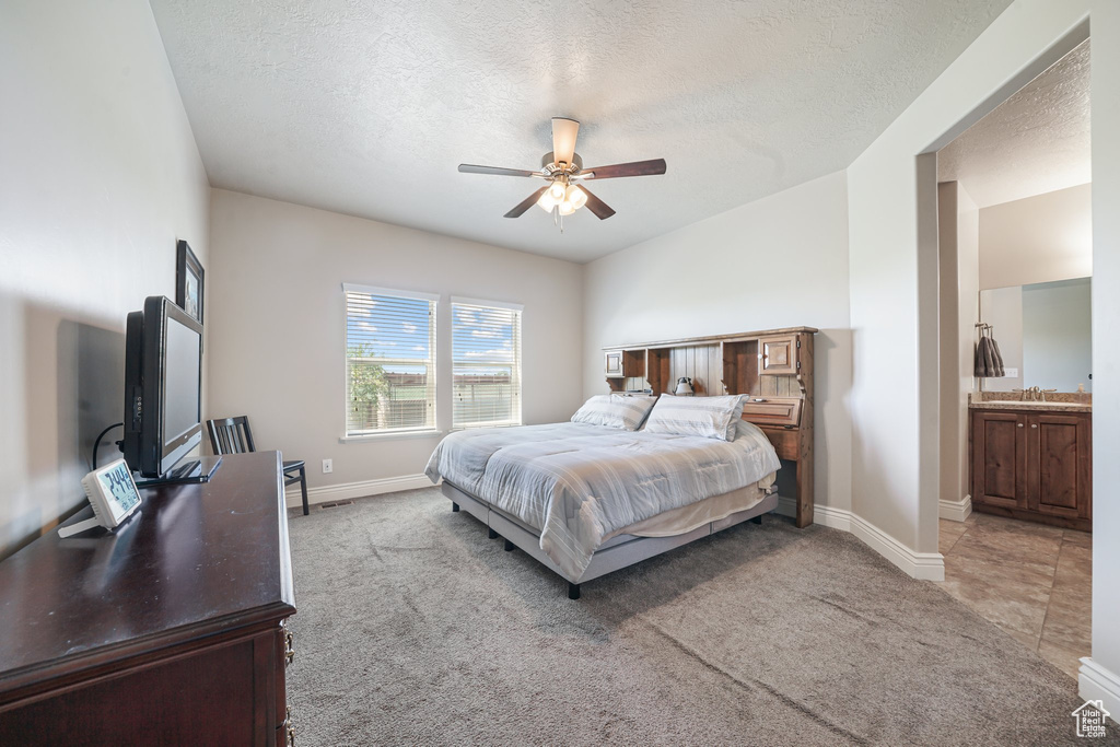 Bedroom with light colored carpet, baseboards, a textured ceiling, and a ceiling fan