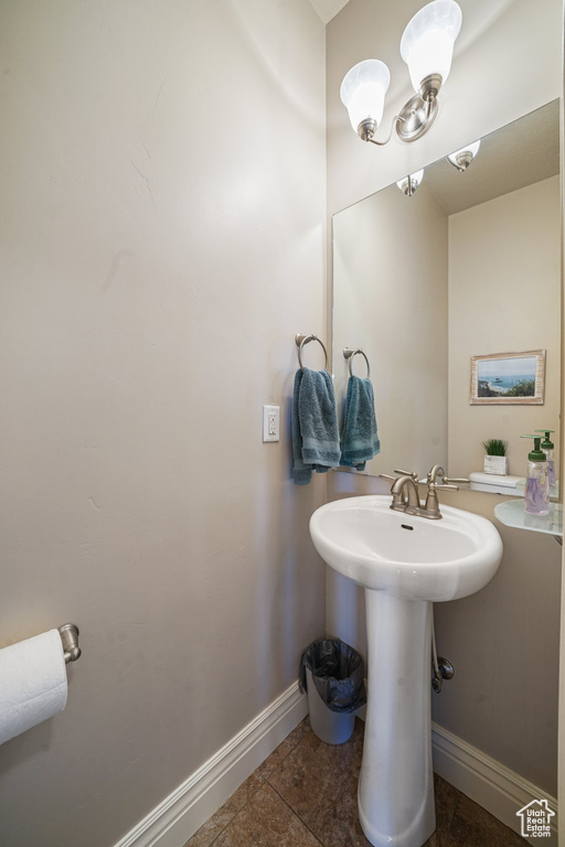 Bathroom featuring baseboards, a sink, and tile patterned flooring