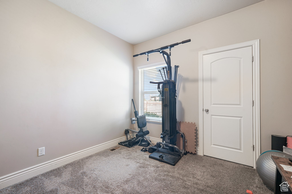 Workout room featuring carpet and baseboards