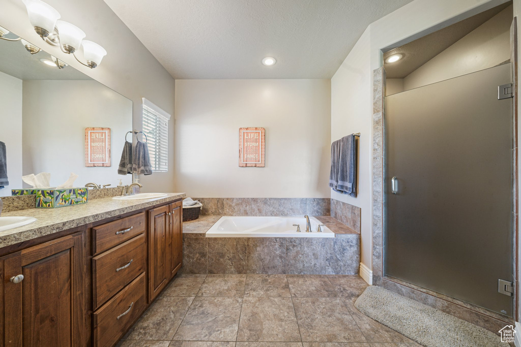 Bathroom with a bath, double vanity, and a shower stall