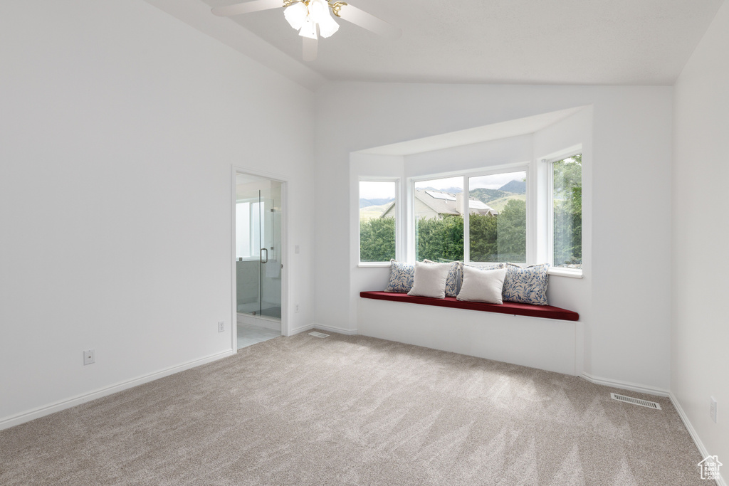 Unfurnished room with carpet floors, ceiling fan, lofted ceiling, and baseboards