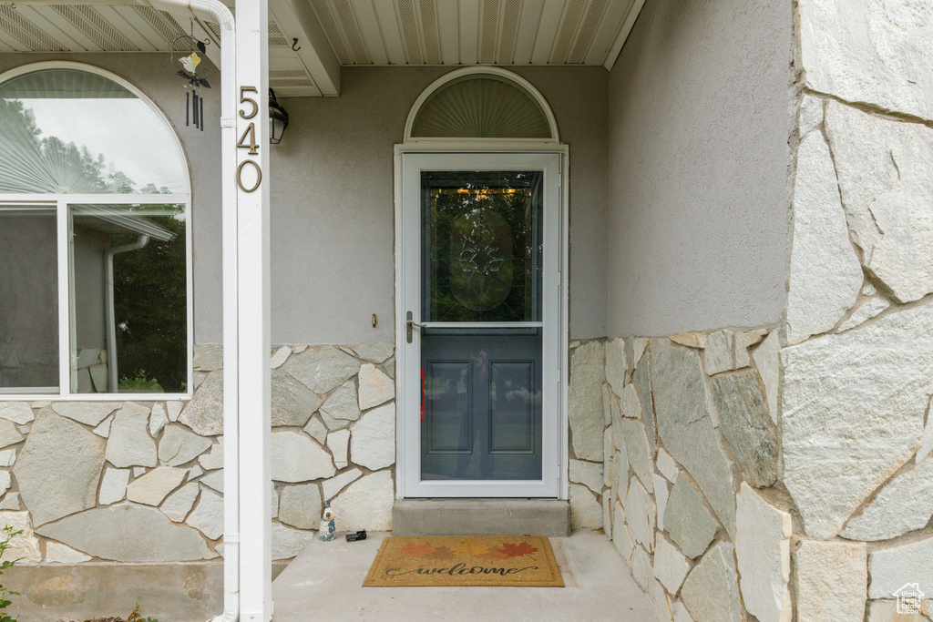 Property entrance with stone siding and stucco siding