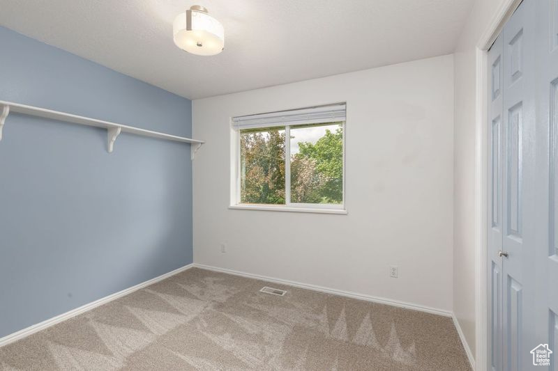 Spare room featuring carpet floors and baseboards