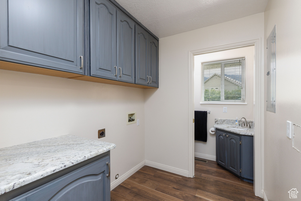 Laundry room with cabinet space, washer hookup, electric dryer hookup, dark wood-style floors, and baseboards