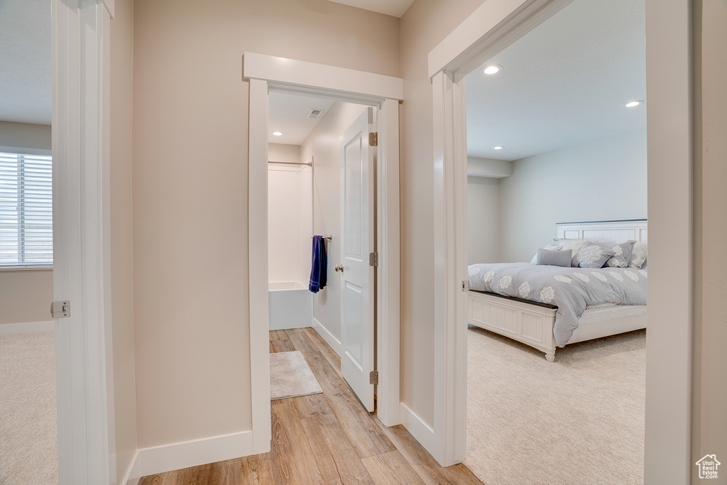Corridor with light wood-style floors, recessed lighting, and baseboards