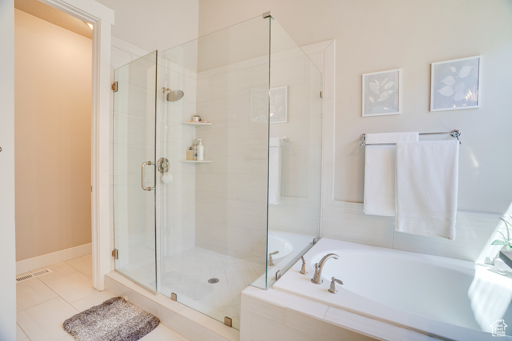 Full bathroom featuring a bath, a shower stall, and tile patterned floors
