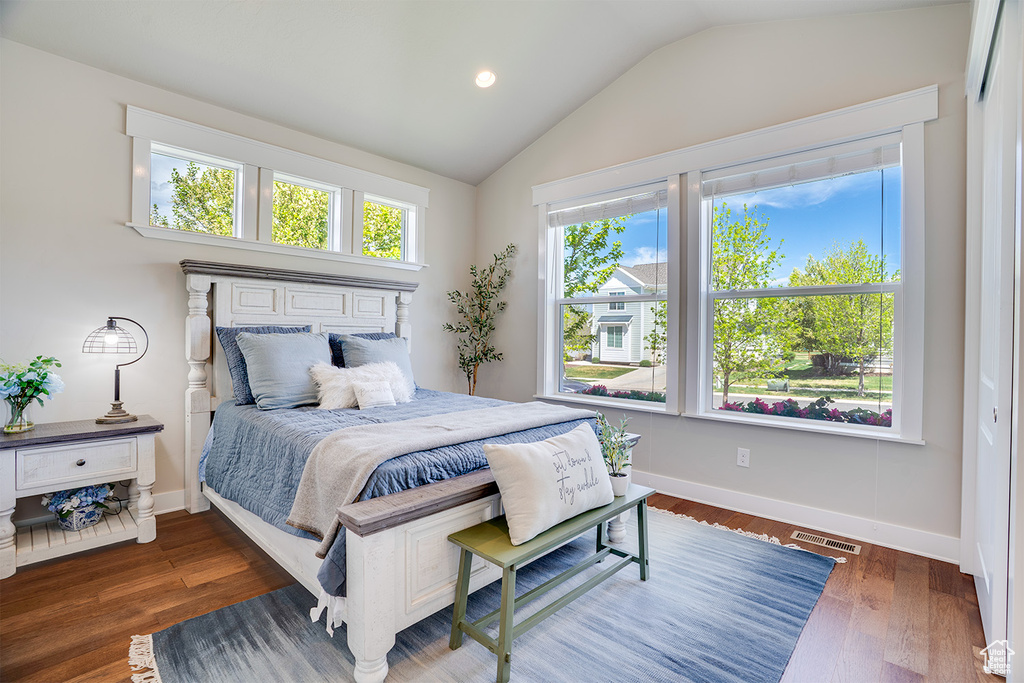 Bedroom with lofted ceiling, wood finished floors, baseboards, and recessed lighting