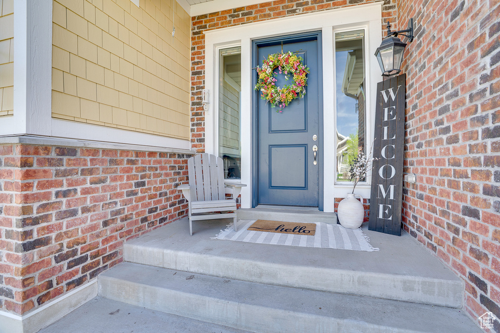 Doorway to property featuring brick siding