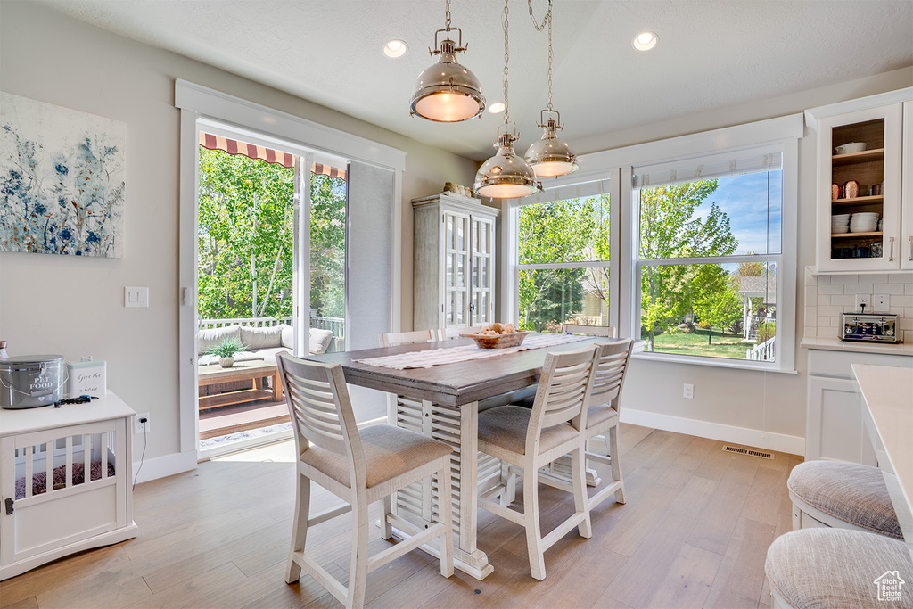 Dining area featuring baseboards, light wood-style floors, and recessed lighting