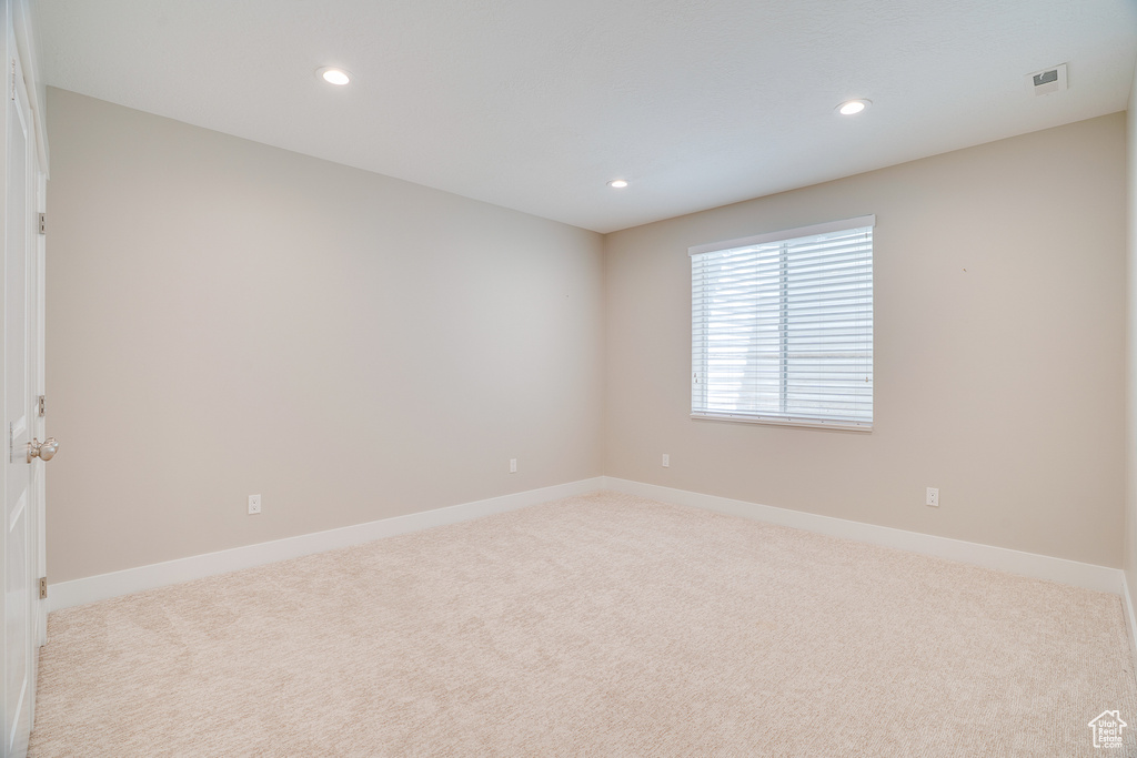 Spare room featuring carpet flooring, baseboards, and recessed lighting